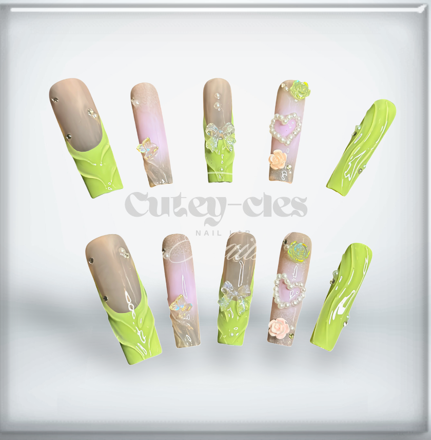 Long pastel green and nude press-on nails with 3D pearls, bows, hearts, and floral designs in a coffin shape.