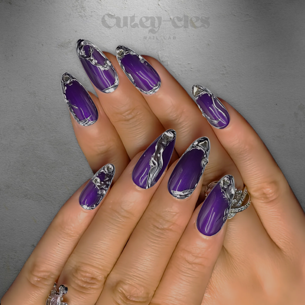 Medium almond nails featuring deep amethyst purple polish with silver metallic 3D chrome accents