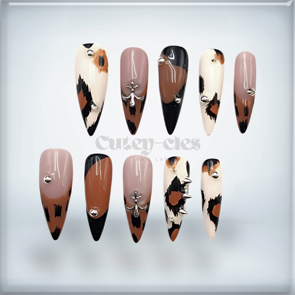 stiletto press-on nails featuring animal print, gold studs, and glossy finish