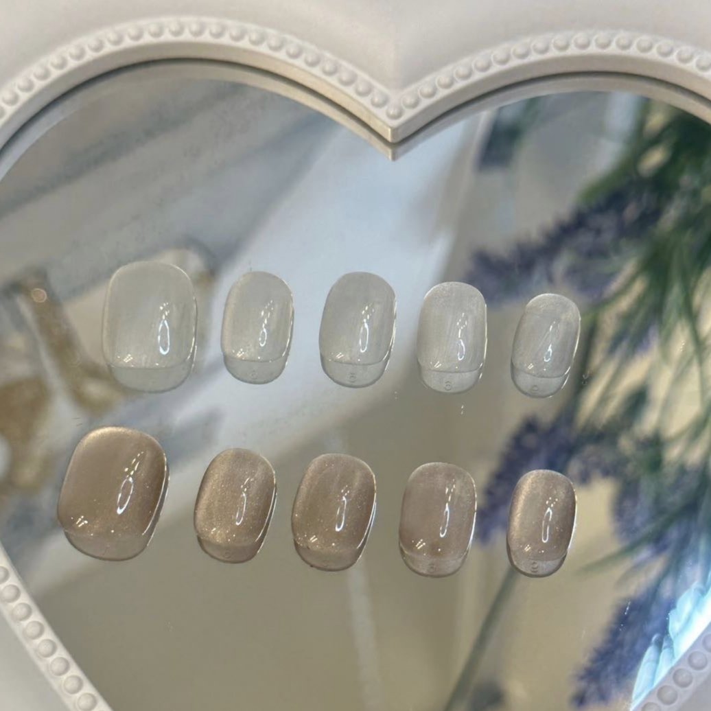 Handmade neutral and white short oval press-on nails with a minimalist, soft finish.