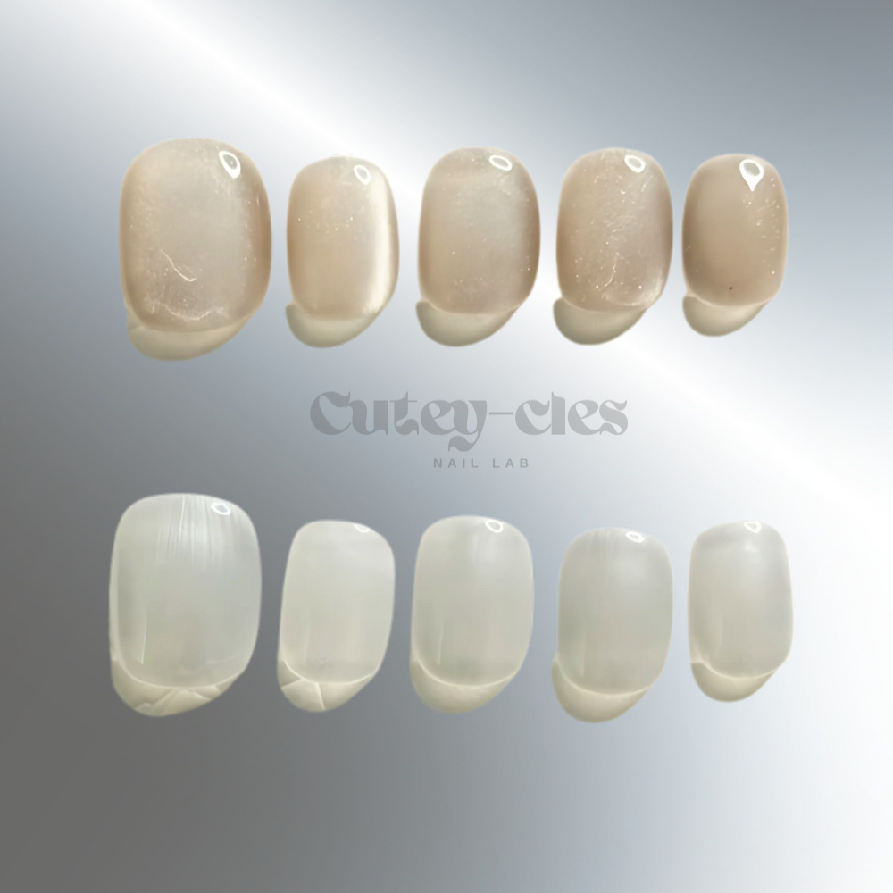 Handmade neutral and white short oval press-on nails with a minimalist, soft finish.
