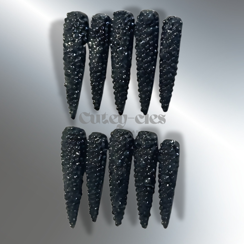 Extra-long black stiletto press-on nails with 3D textured design for a bold and edgy look.