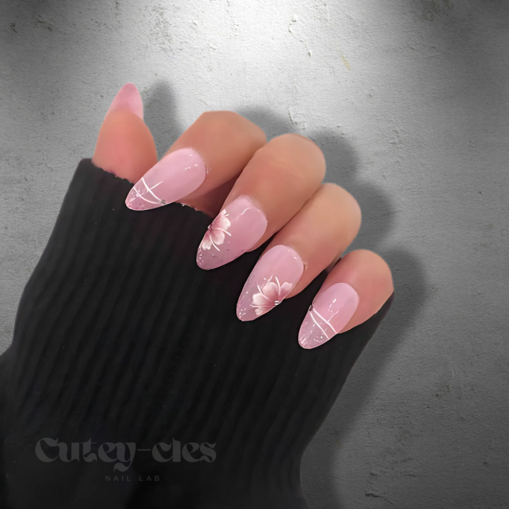 Pink press-on nails with glitter accents and 3D flower designs. Elegant, medium-length nails perfect for adding a touch of romance and sophistication to any look.