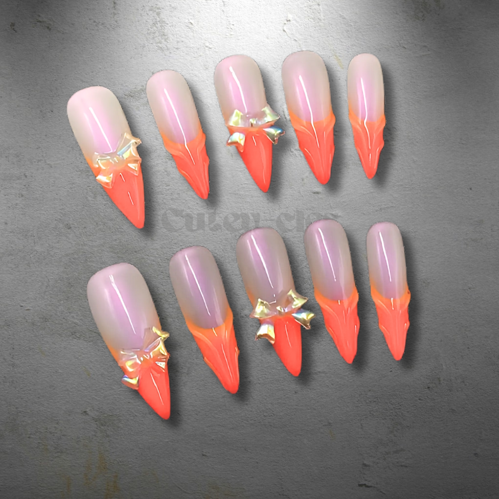 Fiery stiletto press-on nails with orange-to-red ombre gradient and 3D bow embellishments.