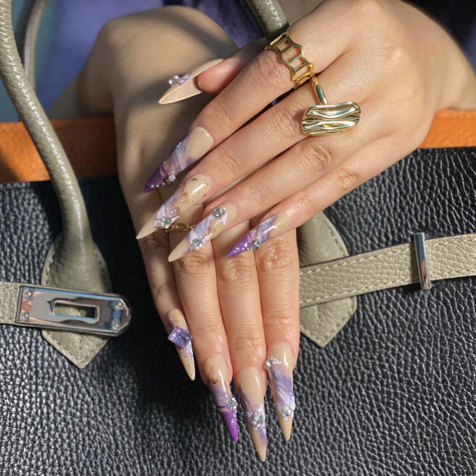 3XL long stiletto press-on nails in peach and lavender with 3D floral embellishments and marbled Art Nouveau-inspired design.