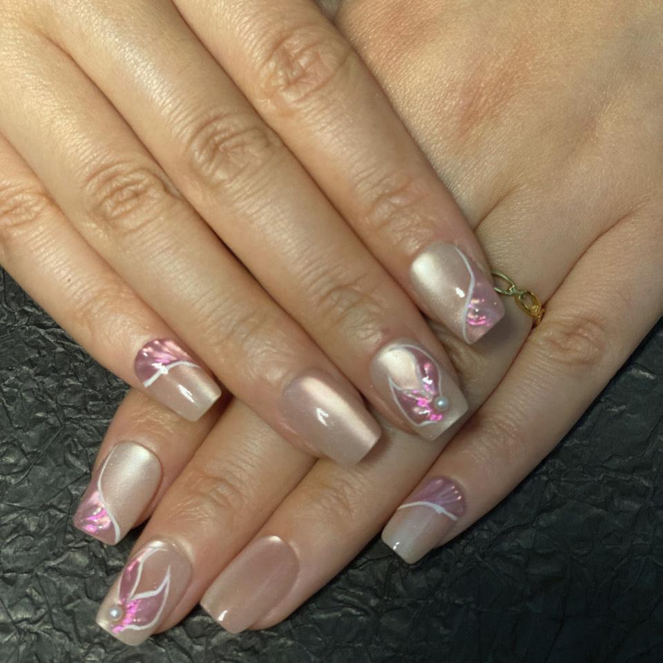 Elegant nude press-on nails with subtle 3D floral accents and soft pink highlights for a timeless look.