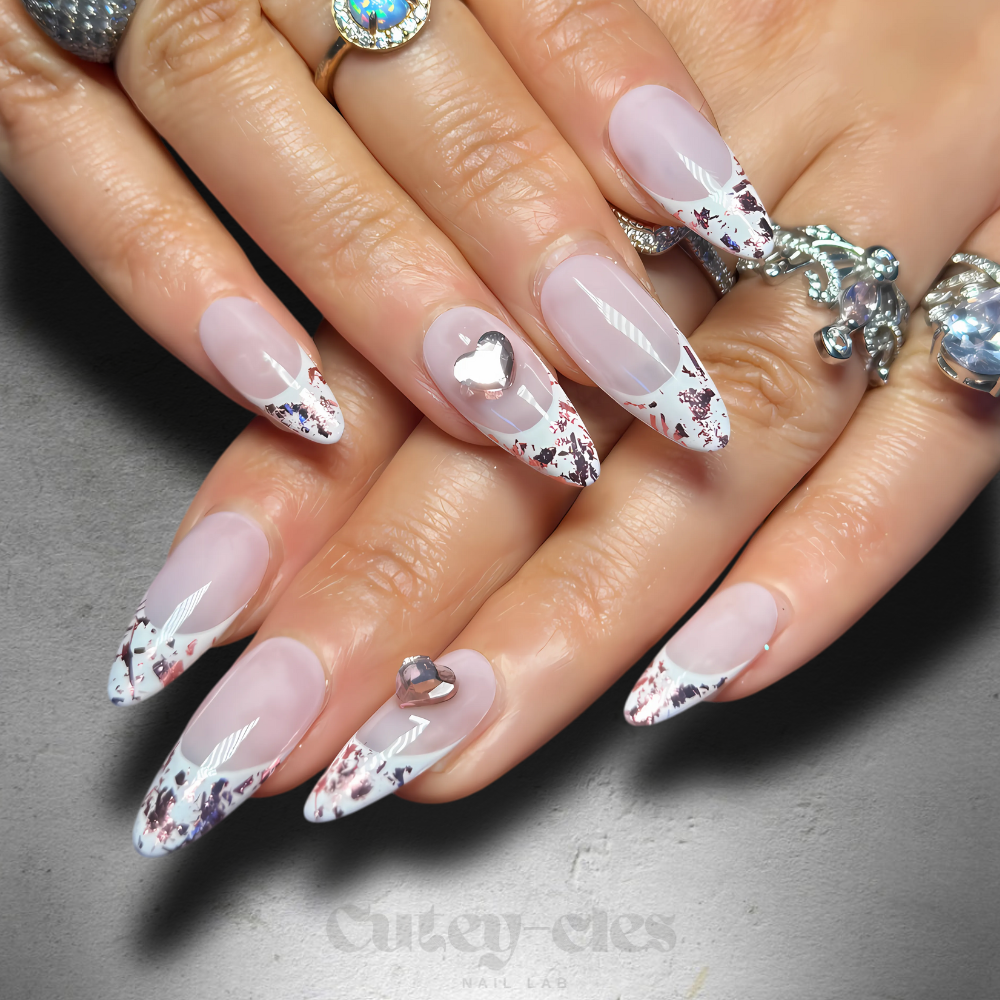 rose gold foil French tip press-on nails with heart accents and a glossy finish.