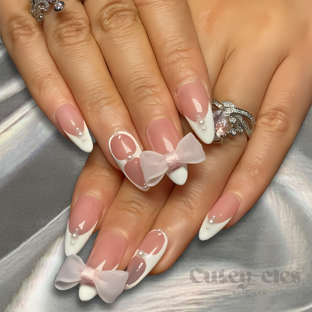 French tip press-on nails with pink bows and pearl accents, ideal for a feminine and elegant look.