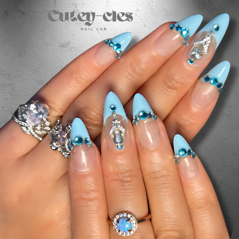 Almond-shaped press-on nails with blue tips, aquamarine and crystal embellishments