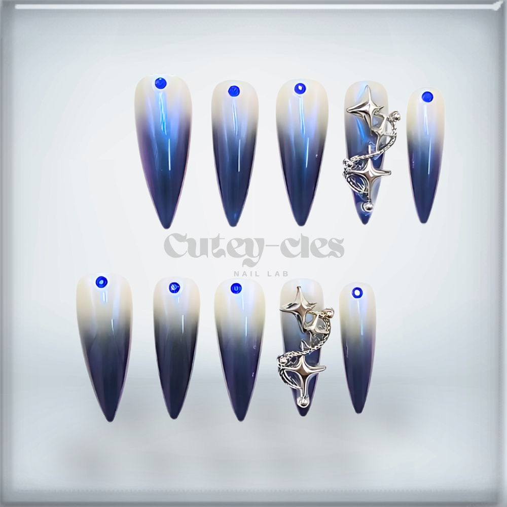 Celestial blue ombré stiletto press-on nails with rhinestone accents and star charm.