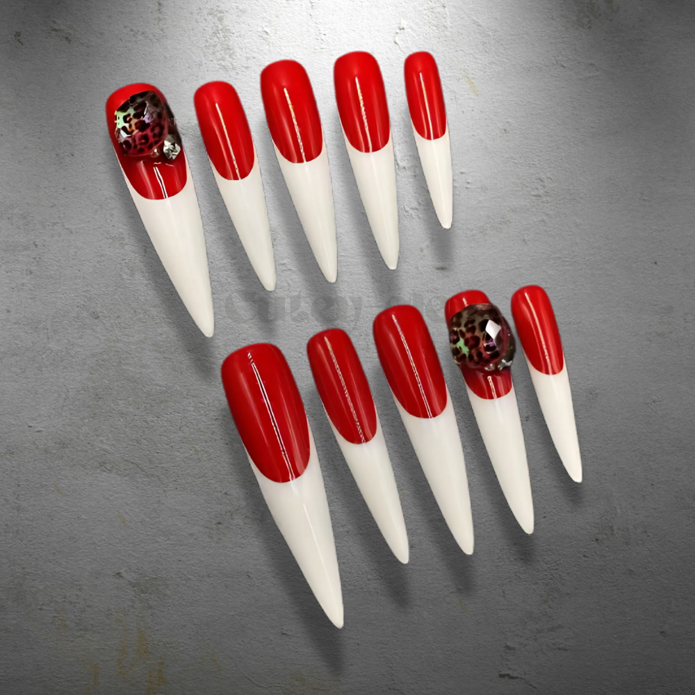 3XL stiletto nails with bold red polish and white tips, featuring a floral embellishment for a dramatic and stylish design.