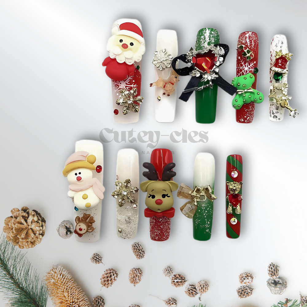 Christmas-themed press-on nails featuring 3D designs of Santa Claus, a reindeer, a snowman, and festive holiday accents in red, green, and gold.