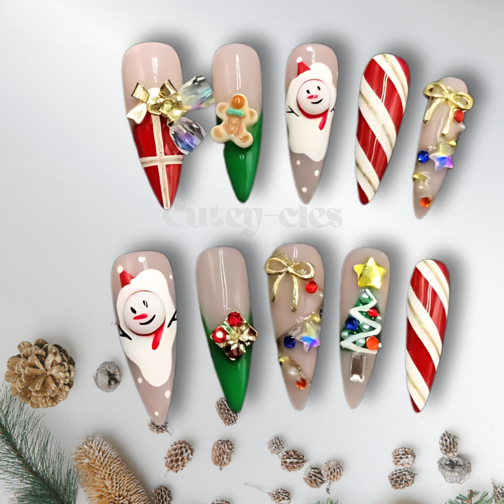 Christmas-themed stiletto press-on nails with 3D designs, including candy canes, gingerbread men, bows, and festive ornaments in red, green, and white.