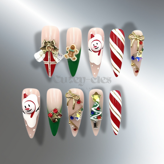 Christmas-themed stiletto press-on nails with 3D designs, including candy canes, gingerbread men, bows, and festive ornaments in red, green, and white.