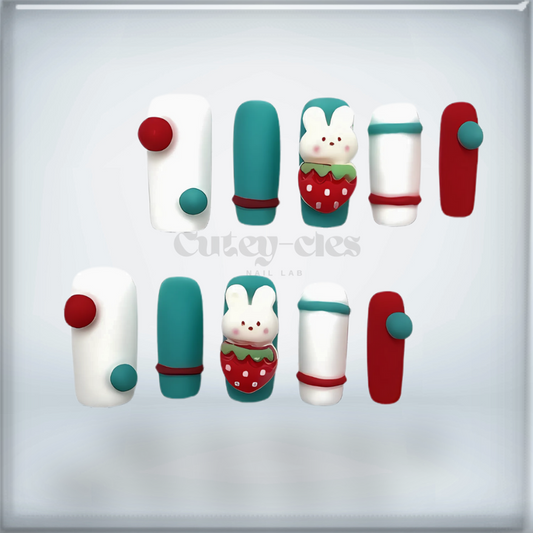 Adorable strawberry bunny-themed 3D press-on nails with a mix of red, green, and white tones, featuring handmade kawaii designs.