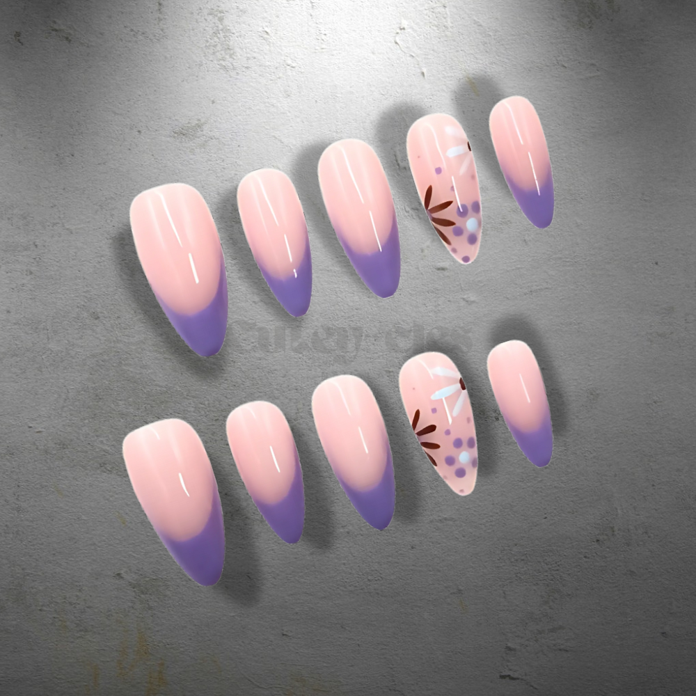 Medium-length almond-shaped press-on nails with pastel purple French tips and hand-painted floral accents on a blush pink base.