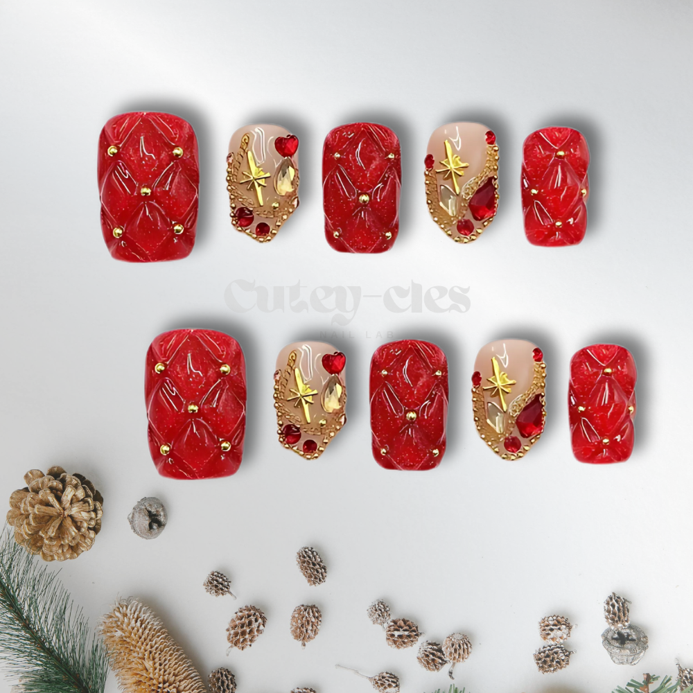 Red quilted press-on nails with gold accents and gemstone embellishments, designed for the holiday season.