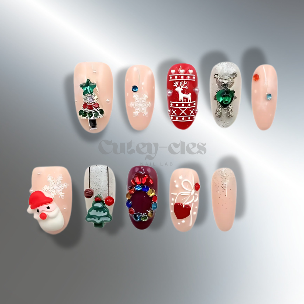 Christmas-themed press-on nails featuring 3D designs of Santa, reindeer, Christmas tree, wreath, snowflakes, and festive accents on a nude base.