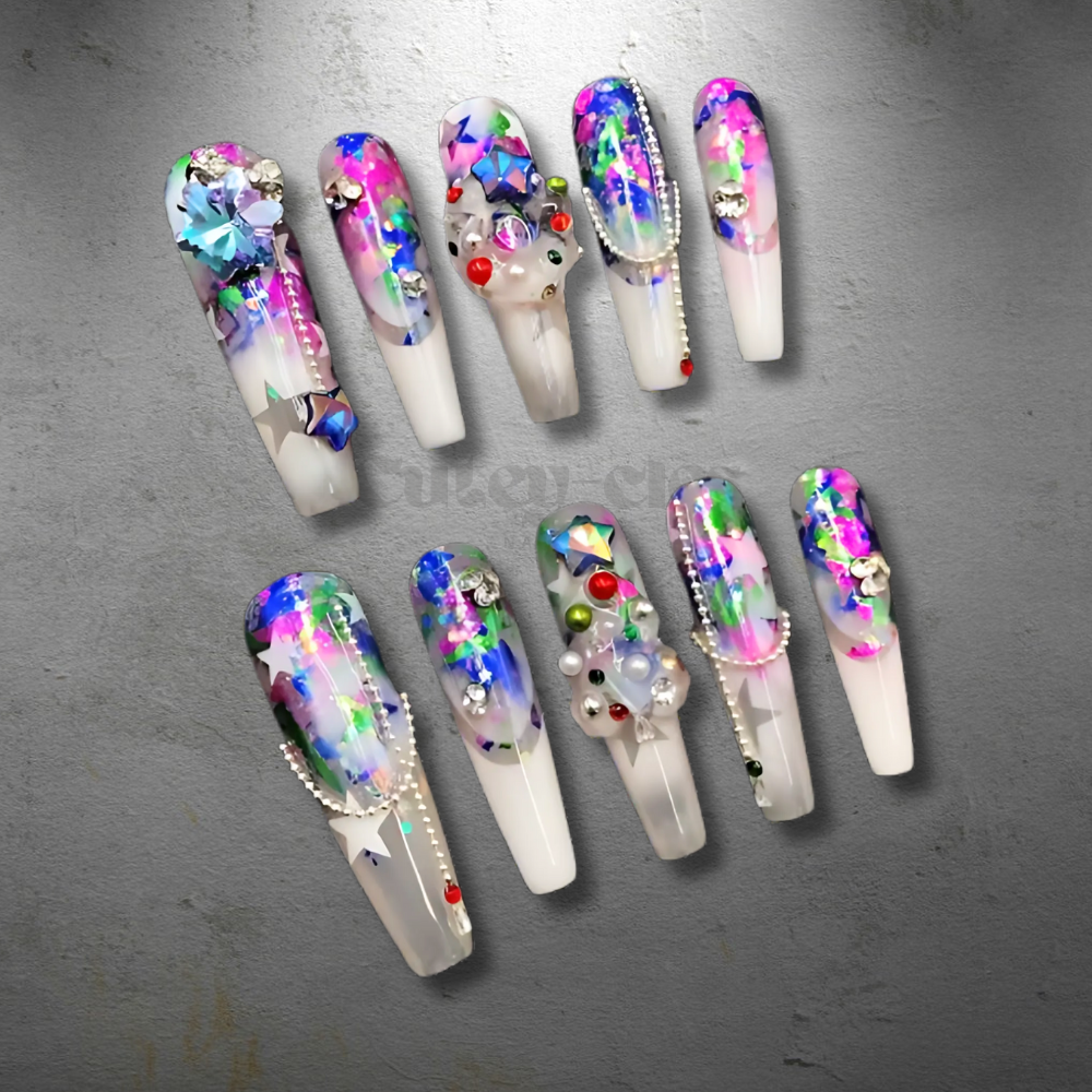 Vibrant 3D press-on nails with abstract holographic patterns, colorful rhinestones, and iridescent foil accents on a transparent base.