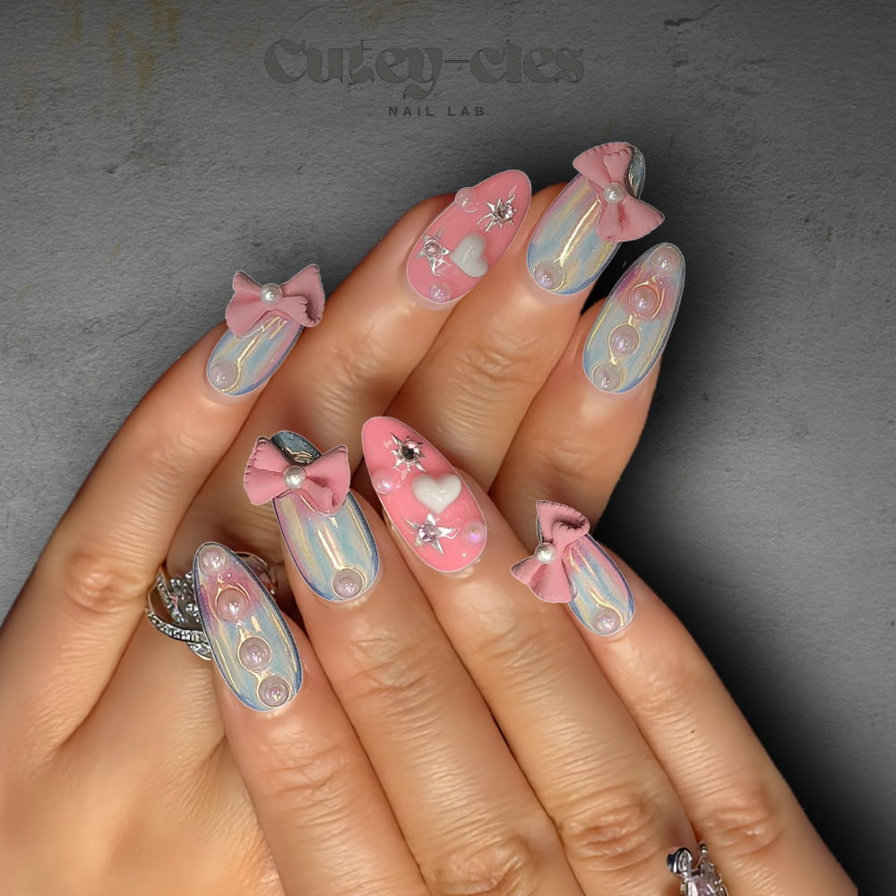 Medium almond press-on nail set showcasing pastel gradient designs, 3D bows, and pearls for a whimsical look.