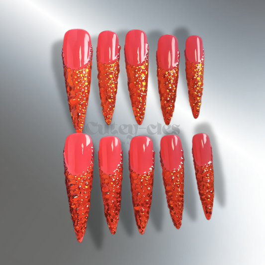 Vibrant 3D red stiletto nails with crystal embellishments, showcasing a bold and luxurious design.