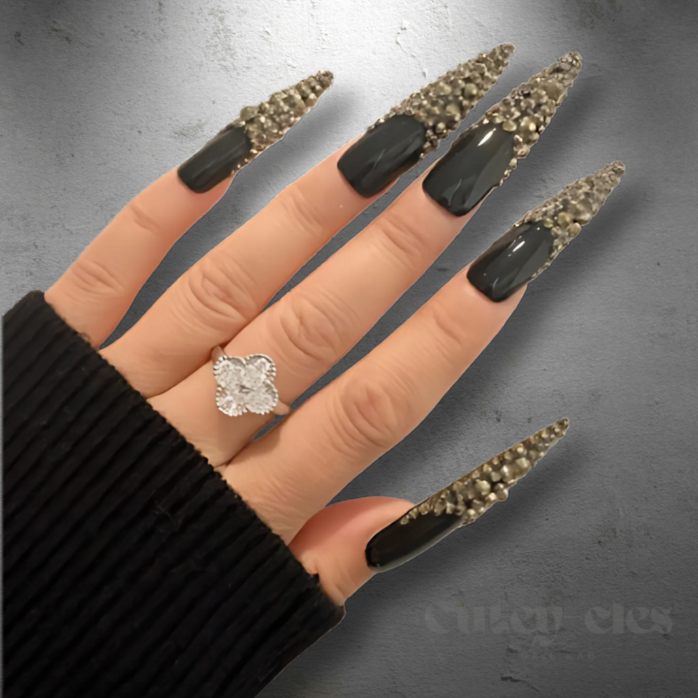 3XL black stiletto nails adorned with gold crystals French tips, showcasing a glamorous, luxurious nail design