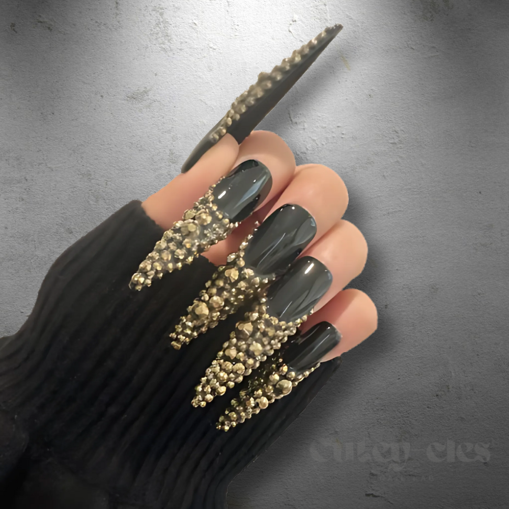 3XL black stiletto nails adorned with gold crystals French tips, showcasing a glamorous, luxurious nail design