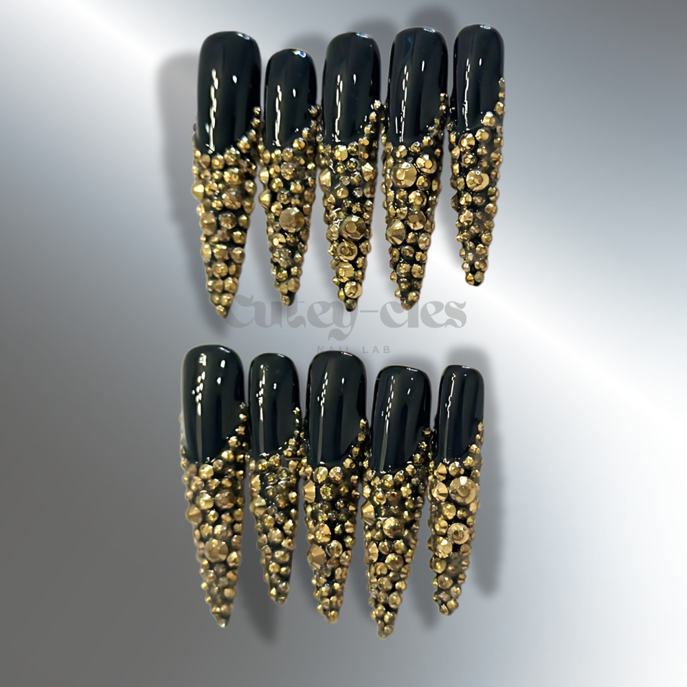 3XL black stiletto nails adorned with gold crystals, showcasing a glamorous, luxurious nail design