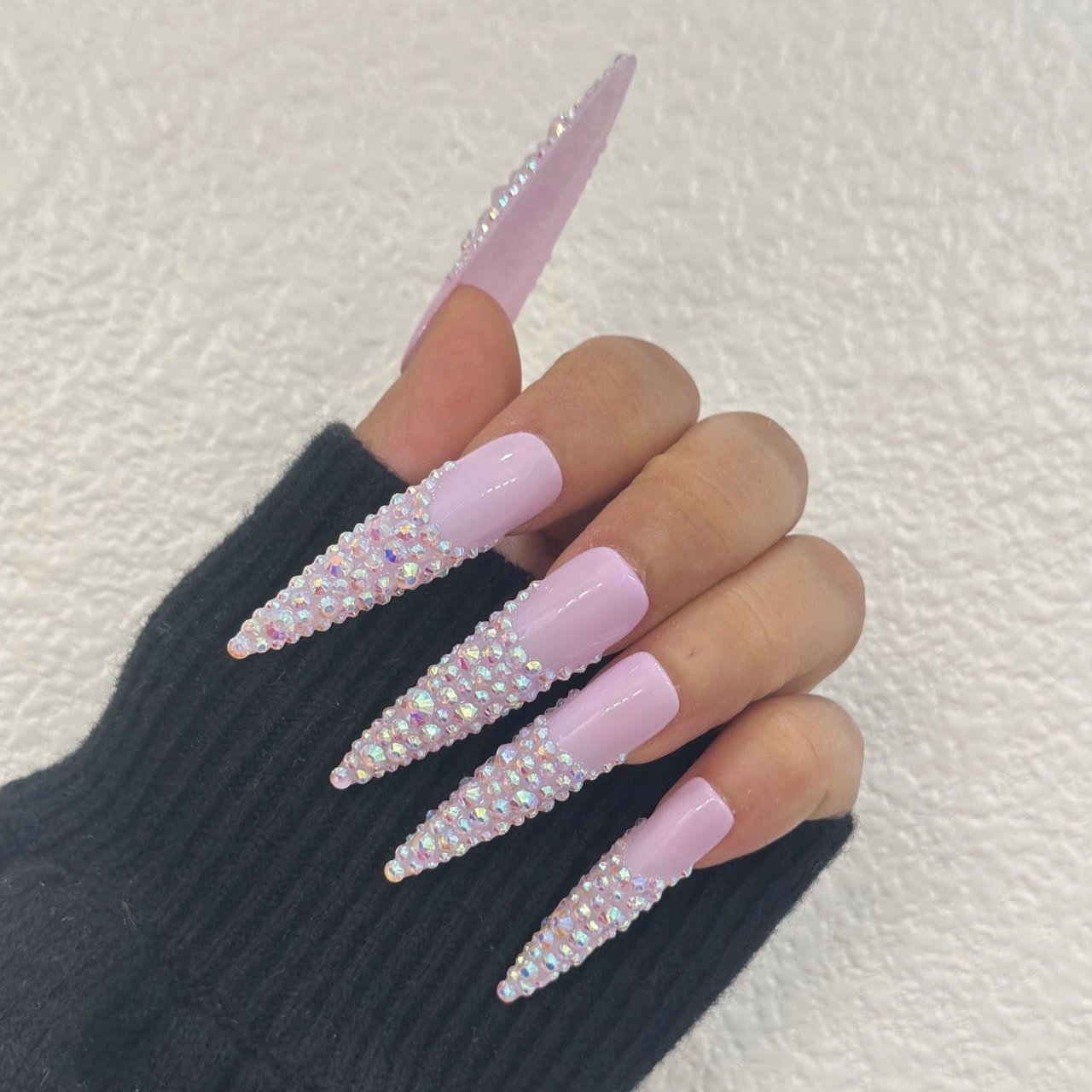 iridescent pink stiletto press-on nails adorned with sparkling crystals for a glamorous and elegant look.