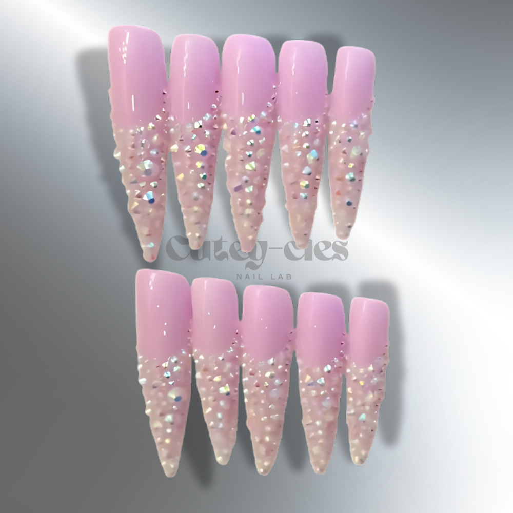 iridescent pink stiletto press-on nails adorned with sparkling crystals for a glamorous and elegant look.