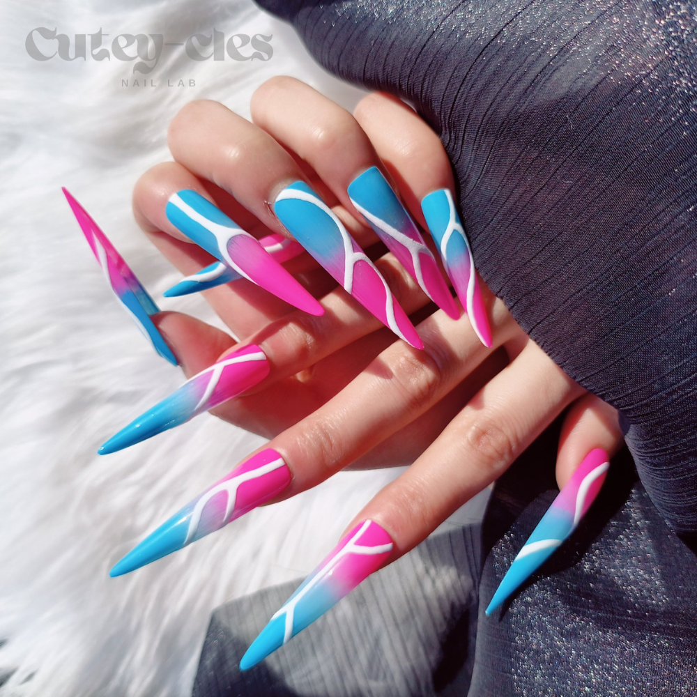 3XL stiletto press-on nails with a vibrant neon pink and blue base, featuring bold abstract white line art and a dramatic glossy finish.