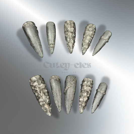 2XL silver stiletto press-on nails with sparkling glitter and rhinestone embellishments, shown on hands with luxurious rings